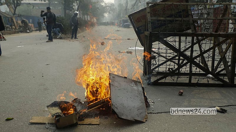 এনইআইআর চালুর প্রতিবাদে মোবাইল ফোনের ‘গ্রে মার্কেটের’ ব্যবসায়ীরা রোববার রাজধানীর কাওরানবাজারে সড়কে আগুন জ্বালিয়ে বিক্ষোভ করেন। ছবি: আব্দুল্লাহ আল মমীন