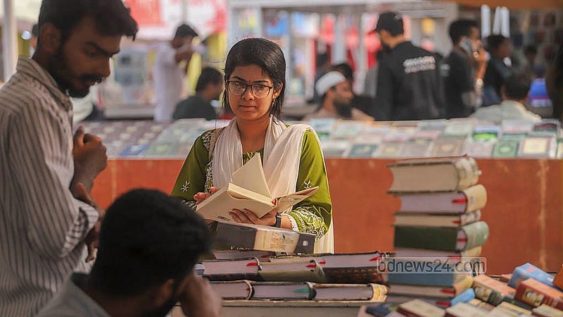 বইমেলায় শুক্রবার একটি স্টলে বই দেখছেন এক তরুণী। ছবি: আব্দুল্লাহ আল মমীন