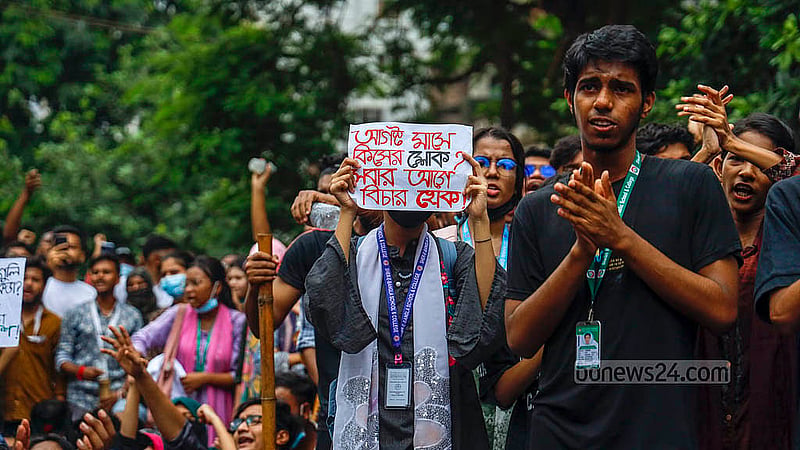 বিভিন্ন দাবির প্ল্যাকার্ড হাতে শনিবার ঢাকার আফতাবনগরের ইস্ট ওয়েস্ট বিশ্ববিদ্যালয়ের সামনে শিক্ষার্থীরা। ছবি: মাহমুদ জামান অভি