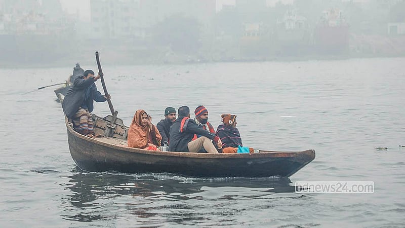 শীতের সকালে ঢাকার সদরঘাট এলাকায় নৌকায় জবুথবু হয়ে বুড়িগঙ্গা নদী পাড় হচ্ছে মানুষ