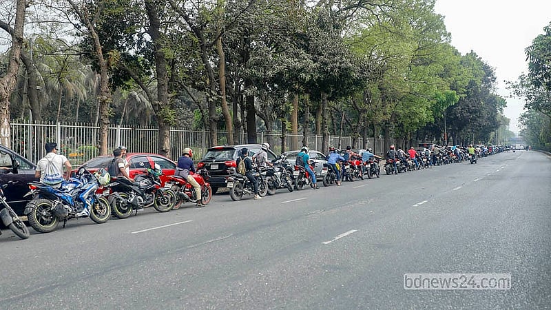 রাজধানীর আসাদগেট এলাকার একটি ফিলিং স্টেশন থেকে তেল নেওয়ার জন্য মিরপুর রোডে মোটরসাইকেলের দীর্ঘ লাইন।  ছবি: আব্দুল্লাহ আল মমীন