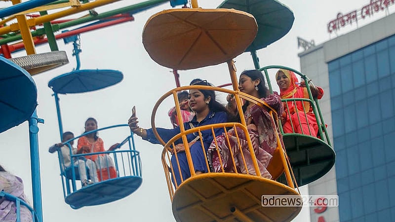 ঢাকার শ্যামলীর শিশু মেলায় রাইডে চড়ার সময় ছবিও তোলেন অনেকে