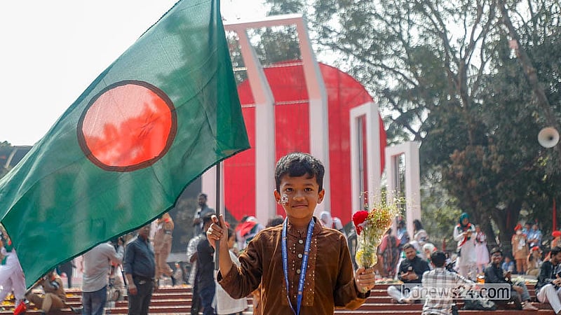 আন্তর্জাতিক মাতৃভাষা দিবসে কেন্দ্রীয় শহীদ মিনারের সামনে জাতীয় পতাকা হাতে এক শিশু।  ছবি: আব্দুল্লাহ আল মমীন
