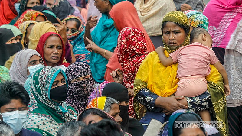 ঢাকার আগারগাঁও এলাকায় টিসিবির ট্রাক থেকে পণ্য কিনতে শিশু সন্তানকে কোলে নিয়ে লাইনে দাঁড়ান এক নারী