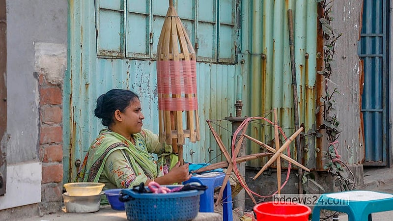 রূপগঞ্জের জামদানি পল্লিতে চরকায় সুতা ঠিক করার কাজ করছেন এক নারী