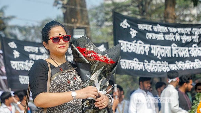 একুশে ফেব্রুয়ারিতে ভাষা শহীদদের শ্রদ্ধা জানাতে ফুল হাতে এক নারী। ছবি: আব্দুল্লাহ আল মমীন