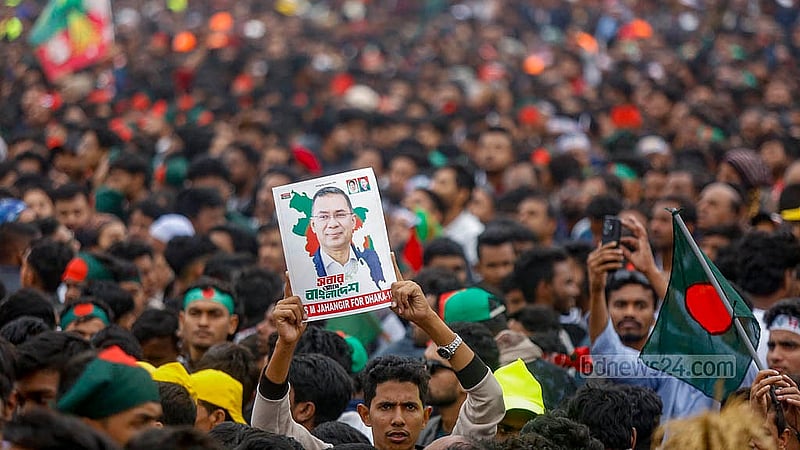 তারেক রহমানের দেশে ফেরার দিনে পূর্বাচলের ৩০০ ফিট সড়কে সংবর্ধনাস্থলে মানুষের ঢল। হাজারো মানুষের ভিড়ে তারেক রহমানের ছবি হাতে এক কর্মী। ছবি: মাহমুদ জামান অভি