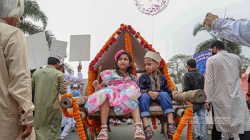 রাজধানীতে ঈদ আনন্দ মিছিলে গরুর গাড়িতে দুই শিশু। সোমবার ঢাকা উত্তর সিটি করপোরেশনের এ আনন্দ আয়োজনে ঢাকার সড়কে গরুর গাড়ি দেখে অবাক হয়েছেন অনেকে।