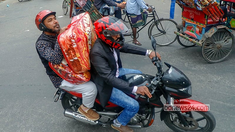 শীতের তীব্রতা বাড়ায় কম্বল কিনে মোটরসাইকেলে করে নিয়ে যাচ্ছেন একজন। রোববার ঢাকা বিশ্ববিদ্যালয় এলাকা থেকে তোলা।  ছবি: আব্দুল্লাহ আল মমীন
