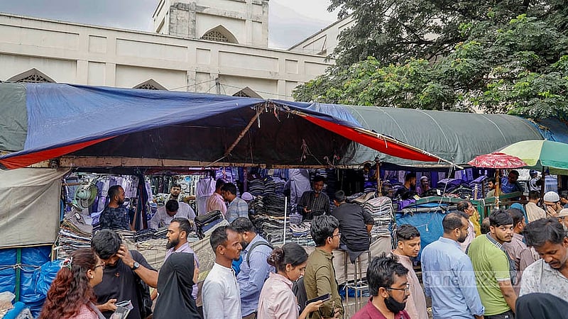 বায়তুল মোকাররম জাতীয় মসজিদের দক্ষিণ গেটের পাশে ফুটপাতের ওপর থাকা যাত্রী ছাউনিটি পুরোটাই হকারদের দখলে। সড়ক থেকে দেখলে বোঝার উপায় নেই যে এটি একটি যাত্রী ছাউনি। ছবি: মাহমুদ জামান অভি