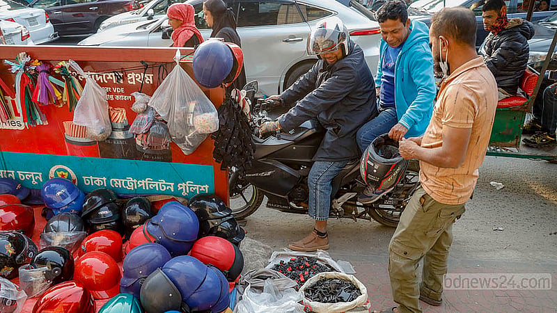 রাজধানীর সায়েন্সল্যাব মোড়ের ফুটপাতে এক বছর ধরে নানান দামের হেলমেট বিক্রি করছেন এক বিক্রি করছেন বাচ্চু মিয়া