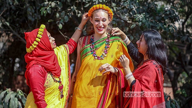 ঢাকা বিশ্ববিদ্যালয় এলাকায় শনিবার বসন্তের সাজে আড্ডায় মেতে উঠেছেন এক বিদেশী নারী