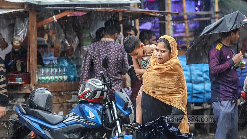বৃষ্টির মধ্যেই সন্তানকে কোলে নিয়ে গন্তব্যে ছুটছেন এক নারী। বৃহস্পতিবার রাজধানীর জুরাইন এলাকা থেকে তোলা। ছবি: আব্দুল্লাহ আল মমীন