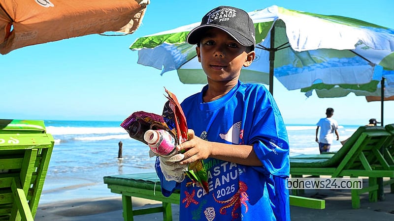 ইন্টারন্যাশনাল কোস্টাল ক্লিনআপের অংশ হিসেবে শুক্রবার সেন্ট মার্টিন সমুদ্র সৈকত থেকে তুলে আনা প্লাস্টিক বর্জ্য হাতে একটি শিশু