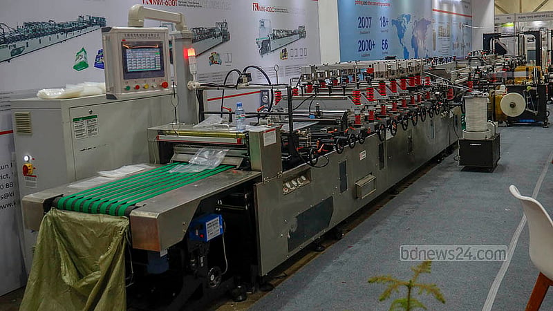 ইন্টারন্যাশনাল কনভেনশন সিটি বসুন্ধরায় আন্তর্জাতিক প্লাস্টিক, প্যাকেজিং ও প্রিন্টিং শিল্প মেলার একটি স্টলে রয়েছে প্লাস্টিক সামগ্রী বানানোর বিভিন্ন ভারী যন্ত্রপাতি