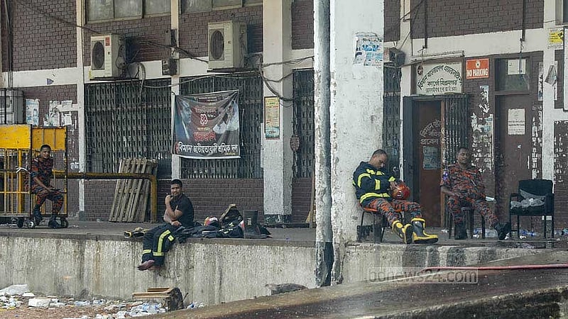 ক্লান্ত ফায়ার সার্ভিস কর্মীদের বসে থাকতে দেখা যায় শাহজালাল আন্তর্জাতিক বিমানবন্দরে কার্গো ভিলেজ কমপ্লেক্সের বারান্দায়। ছবি: আব্দুল্লাহ আল মমীন
