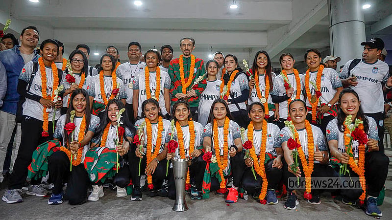 সাফ উইমেনস ফুটসালের প্রথম আসরের ট্রফি হাতে বৃহস্পতিবার শাহজালাল আন্তর্জাতিক বিমানবন্দরে কোচ ও নারী ফুটবলাররা