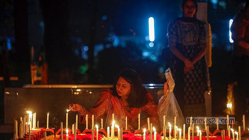 মৃতদের আত্মার শান্তি কামনায় ‘অল সোলস ডেতে’ ঢাকার ওয়ারীতে খ্রিষ্টান সমাধি ক্ষেত্রে একটি সমাধিতে মোমবাতি প্রজ্জলন করছেন এক নারী। ছবি: মাহমুদ জামান অভি