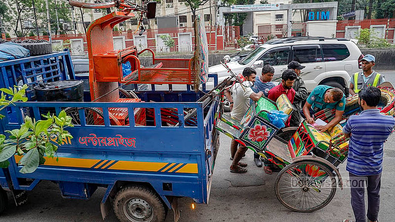রাজধানীর কিছু সড়কে ব্যাটারিচালিত রিকশা চলাচল বন্ধে তৎপর পুলিশ। ধানমন্ডি ২৭ নম্বর মোড়ে দুটি রিকশা আটক করে ডাম্পিংয়ে পাঠিয়ে দেয় পুলিশ। ছবি: মাহমুদ জামান অভি