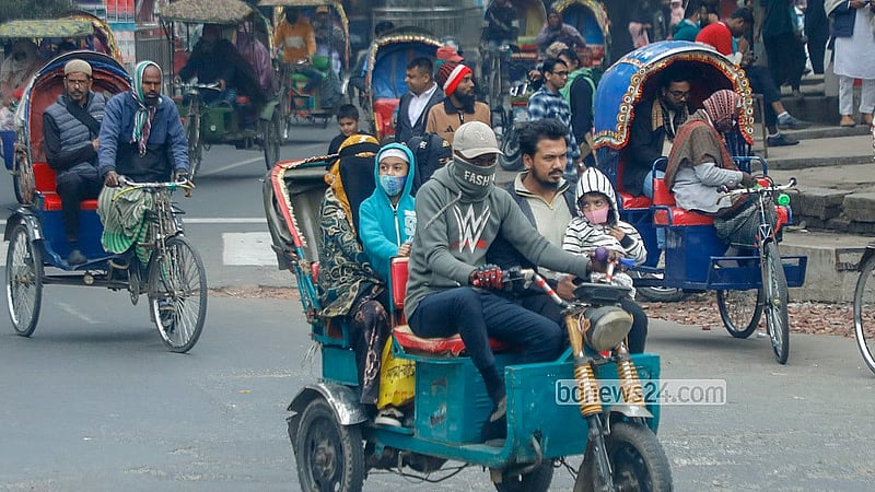 কনকনে ঠান্ডা থেকে রক্ষায় সন্তানকে গরম কাপড়ে মুড়িয়ে রিকশায় করে গন্ত্যেবের পথে এক পরিবার। ঢাকা বিশ্ববিদ্যালয় এলাকা থেকে তোলা। ছবি: আব্দুল্লাহ আল মমীন
