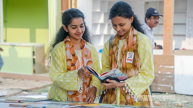 বইমেলার প্রথম দিন বৃহস্পতিবার সোহরাওয়ার্দী উদ্যানে বই দেখছেন দুই তরুণী