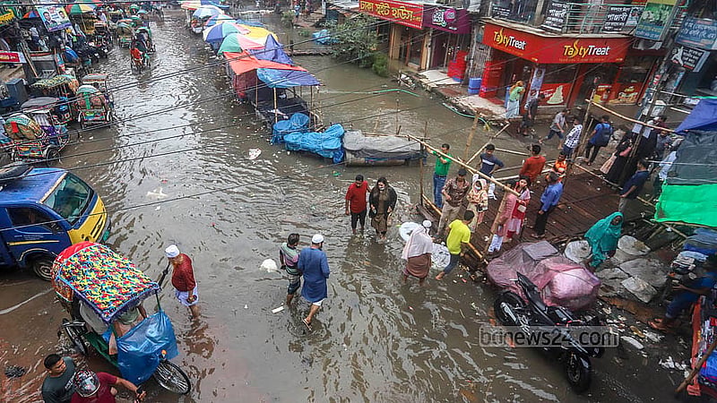 যাত্রাবাড়ীর শনির আখড়ায় খাল ও বৃষ্টির পানি একাকার। শনিবার ডুবে থাকা জিয়া সরণিতে ঝুঁকি নিয়ে চলাচল করে মানুষ ও যানবাহন।ছবি: আব্দুল্লাহ আল মমীন