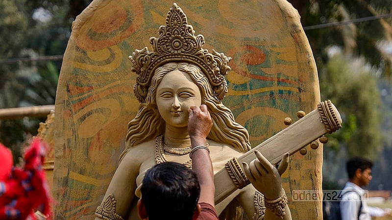ঢাকা বিশ্ববিদ্যালয়ের জগন্নাথ হলে গোবিন্দ চন্দ্র দেব ভবনের সামনে সরস্বতী প্রতিমায় রঙের প্রলেপ দেওয়ার আগে সবকিছু ঠিক আছে কি না তা যাচাই করছেন একন মৃৎশিল্পী