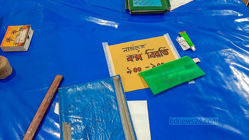 এক দফা দাবিতে মঙ্গলবার ৪ ঘণ্টা কর্মবিরতি পালন করেন নার্সরা। টেবিলের উপর কাগজে লেখা তারই ঘোষণা। মঙ্গলবার ঢাকা মেডিকেল কলেজ হাসপাতালের ২০৬ নম্বর ওয়ার্ডে নার্সদের টেবিলে দেখা গেল এই চিত্র। ছবি: আব্দুল্লাহ আল মমীন