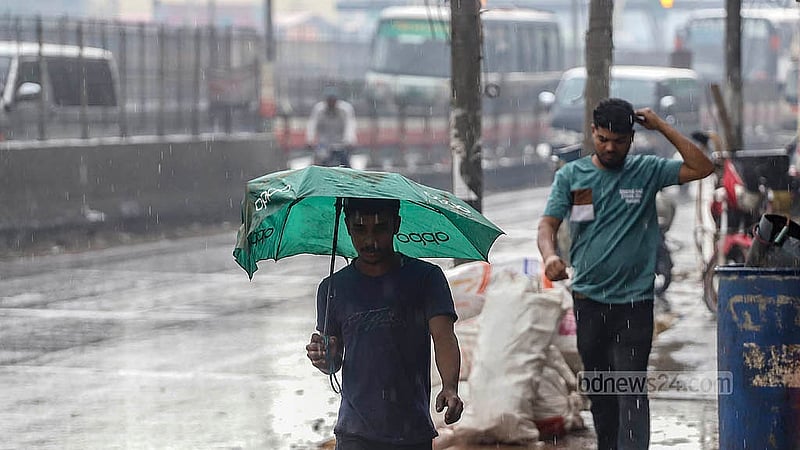 শনিবার দুপুরে বৃষ্টির মধ্যে ছাতা মাথায় ছুটছে মানুষ; সকালে মেঘলা আকাশের কারণে অনেকেই সঙ্গে ছাতা নিয়ে বের হন। ছবি: আব্দুল্লাহ আল মমীন