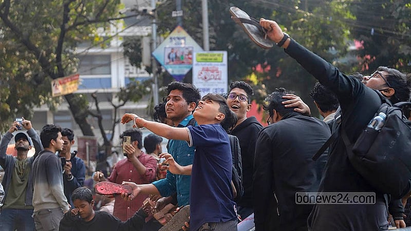ঢাকা বিশ্ববিদ্যালয়ের রাজু ভাস্কর্য সংলগ্ন মেট্রোরেলের পিলারে শেখ হাসিনার গ্রাফিতিতে সোমবার ‘গণ জুতা নিক্ষেপ কর্মসূচি’ পালন করা হয়। ছবি: আব্দুল্লাহ আল মমীন