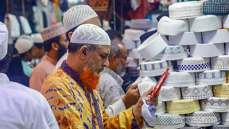 রোজার ঈদ সামনে রেখে বায়তুল মোকাররম মসজিদের সামনে একটি দোকানে টুপি দেখছেন ক্রেতা। ছবি: আব্দুল্লাহ আল মমীন