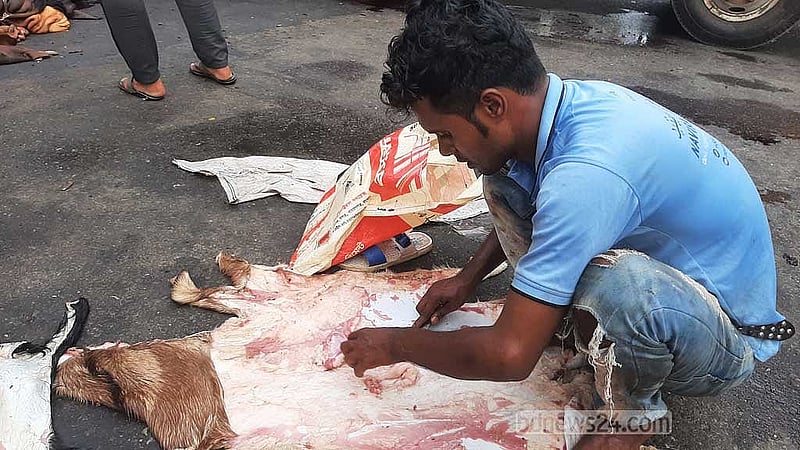 গুলশান এলাকায় সড়কের চামড়া ফেলে মাংস ছাড়াচ্ছেন অখিল। 