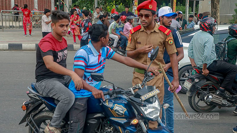 এই মোটরসাইকেলের দুই আরোহীর মাথায় নাই হেলমেট, বিজয় সরণী মোড়ে তাদের থামিয়ে দেন এক শিক্ষার্থী।