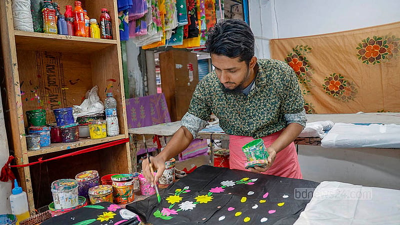 ঢাকার নিউ মার্কেটে পাঞ্জাবিতে হাতের প্রিন্টের কাজ করছেন মোহাম্মদ মিঠু। ২২ বছর ধরে তিনি এই কাজ করে যাচ্ছেন