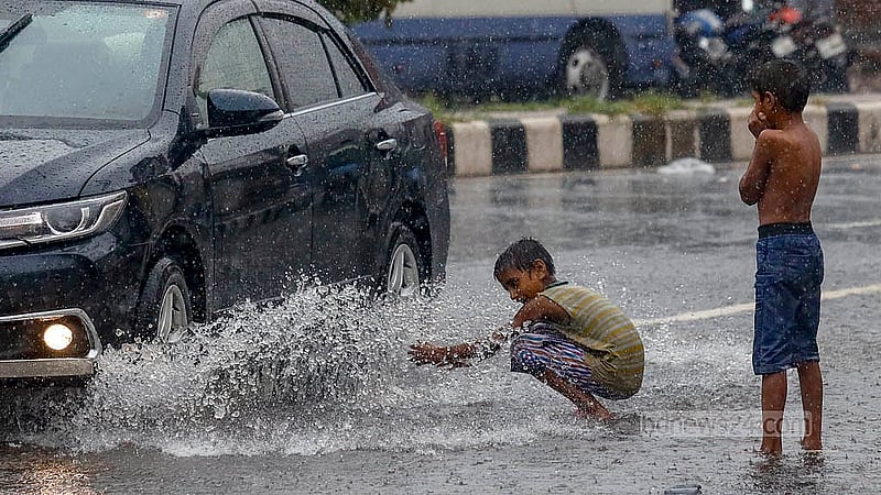 টানা গরমের পর আকাশ কালো করে নেমেছে ঝুম বৃষ্টি। বুধবার দুপুরে বৃষ্টিতে ভিজে দুরান্তপনায় মাতে শিশুরা। ছবি: মাহমুদ জামান অভি