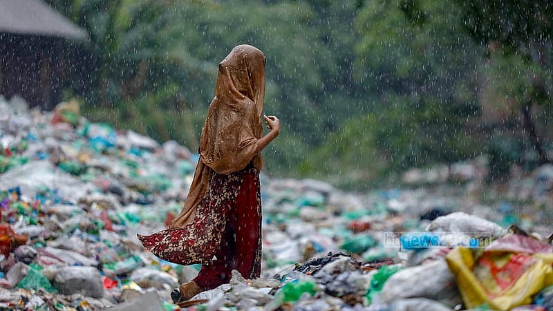 চলার কথা নৌকা, কিন্তু শুভাঢ্যা খালে জমে থাকা পুরু আবর্জনার ওপর দিয়ে হেঁটে যাচ্ছে মানুষ। ছবি: মাহমুদ জামান অভি