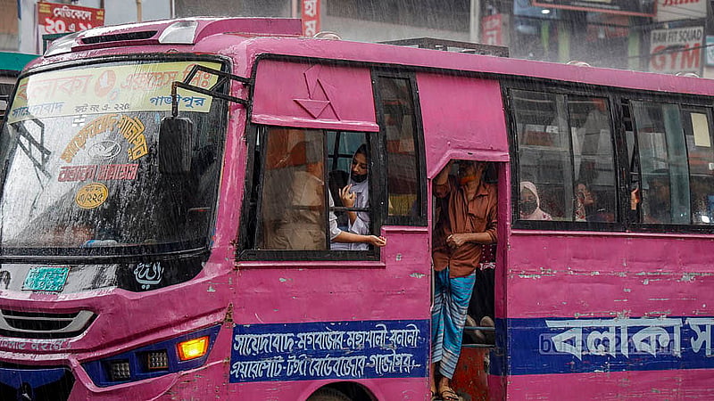 ঢাকার মগবাজার মোড়ে বুধবার দুপুরে ট্রাফিক সিগন্যালে দাঁড়ানো বাসের জানালা দিয়ে হাত বাড়িয়ে বৃষ্টি উপভোগ করেন এক শিক্ষার্থী