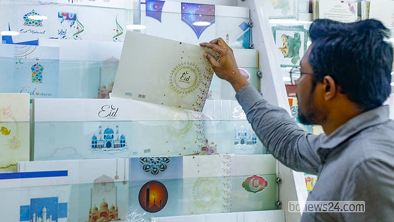 ঈদ কার্ড দেখছেন একজন। প্রিয়জনদের শুভেচ্ছা জানাতে অনেকে এখনো ঈদ কার্ড উপহার দেন