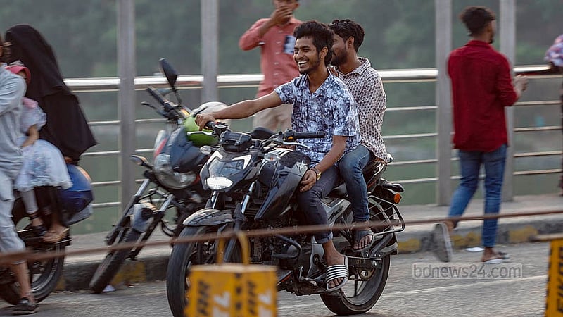 হেলমেট না পরলে জরিমানা করার নিয়ম আছে। কিন্তু ঈদের ছুটিতে পুলিশি তৎপরতা কম থাকায় হেলমেট ছাড়াই বেপরোয়া গতিতে মোটরসাইকেল চলছে হাতিরঝিলে। ছবি: মাহমুদ জামান অভি