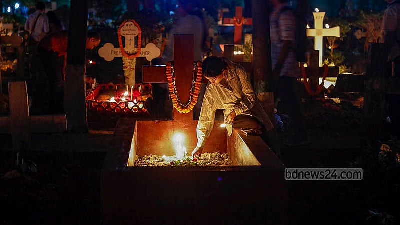 ‘অল সোলস ডেতে’ প্রয়াতদের আত্মার শান্তি কামনায় ঢাকার ওয়ারীতে খ্রিষ্টান সমাধি ক্ষেত্রে একটি সমাধিতে মোমবাতি প্রজ্জলনে এক তরুণী। ছবি: মাহমুদ জামান অভি