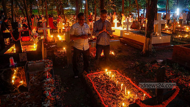 ‘অল সোলস ডেতে'ঢাকার ওয়ারীতে খ্রিষ্টান সমাধি ক্ষেত্রে প্রয়াতদের আত্মার শান্তি কামনায় প্রার্থনা করেন স্বজনরা। ছবি: মাহমুদ জামান অভি