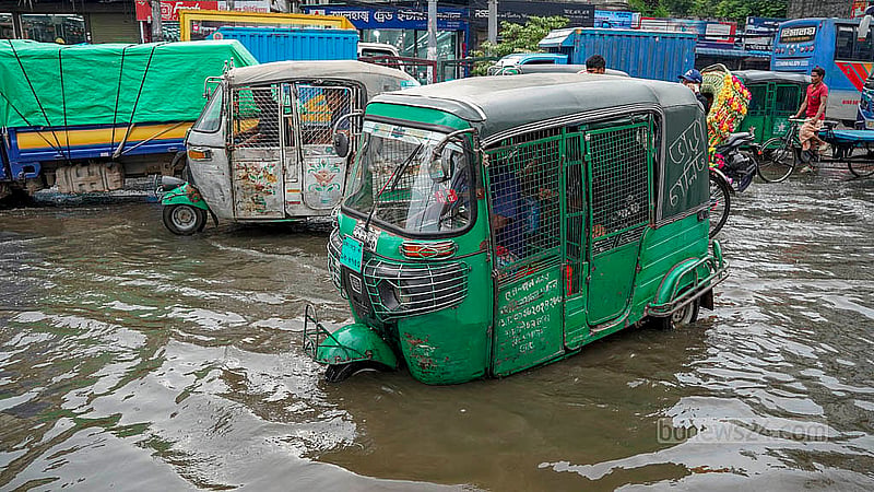 রাজধানীর প্রগতি সরণিতে মঙ্গলবার দুপুরে জলজটের মধ্যেই চলে যানবাহন
