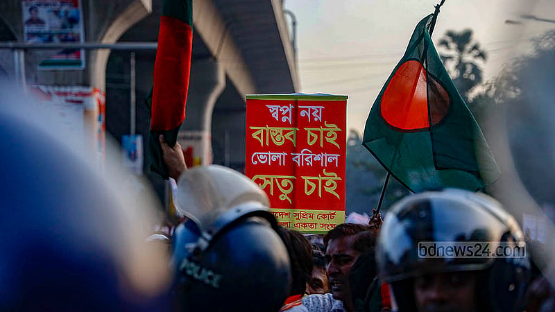বরিশাল-ভোলা সেতুর দাবিতে ব্যানার-পোস্টার হাতে শুক্রবার বিকালে শাহবাগ মোড় অবরোধ করে স্লোগান দেন ঢাকায় থাকা ভোলার বাসিন্দারা