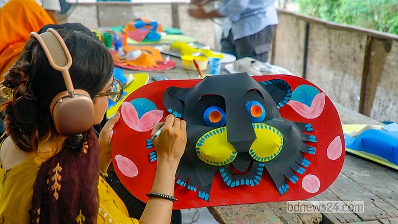 ঢাকা বিশ্ববিদ্যালয়ের চারুকলা অনুষদে বুধবার কাগজের তৈরি মুখোশে রঙ করেন এক শিক্ষার্থী