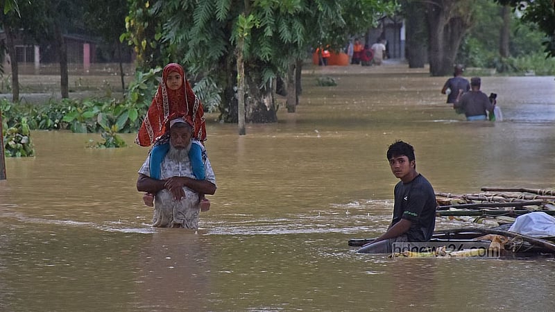 ফেনীর ফাজিলপুরে রোববার নাতনিকে কাঁধে নিয়ে নিরাপদ আশ্রয়ের সন্ধানে এক বৃদ্ধ। ছবি: সুমন বাবু
