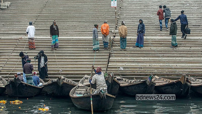 শীতের সকালে সদরঘাট এলাকায় বুড়িগঙ্গা নদীর পাড়ে যাত্রীর অপেক্ষায় মাঝিরা