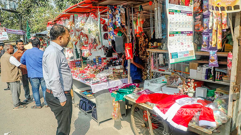 খ্রিষ্টান ধর্মাবলম্বীদের প্রধান ধর্মীয় উৎসব বড়দিন উপলক্ষে ঢাকার তেজগাঁও চার্চের সামনে থেকে সান্তা ক্লজের পোশাক কিনছে কেউ কেউ
