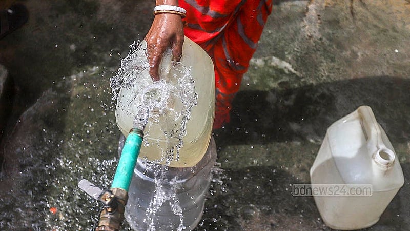 লালবাগের আমলিগোলা এলাকায় সড়কের পাশে ওয়াসার কল থেকে খাবার পানি সংগ্রহ করেন স্থানীয়রা। ছবি: আব্দুল্লাহ আল মমীন