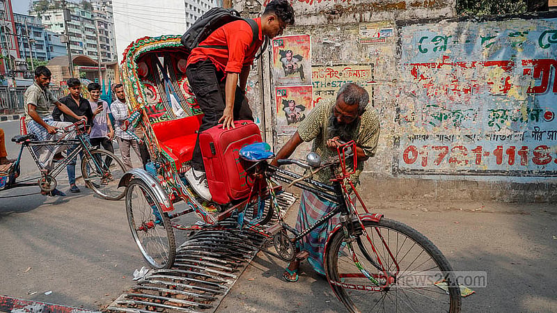 কাকরাইলে ট্র্যাপারের ওপর দিয়ে যেতে অসুবিধে হওয়ায় যাত্রী নামিয়ে রিকশা নিয়ে যাচ্ছেন চালক। ছবি: মাহমুদ জামান অভি