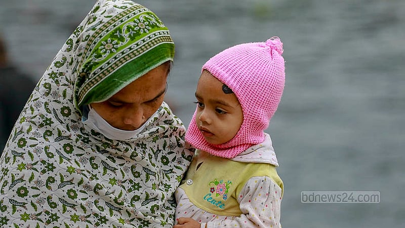 ঢাকায় বুধবার সকালে শীতে জবুথবু এই নারী শিশু সন্তানকে নিয়ে নৌকায় পার হচ্ছেন বুড়িগঙ্গা নদী। ছবি: মাহমুদ জামান অভি